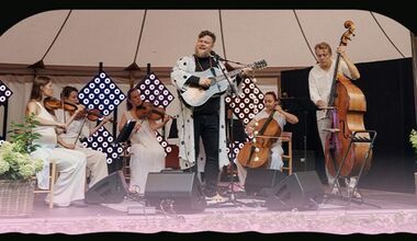 Foto af en gruppe musikere med guitarer og strygeinstrumenter.