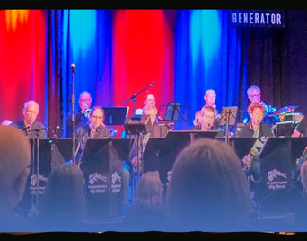 Foto af et band med forskellige instrumenter og en orange-blå stribet baggrund.