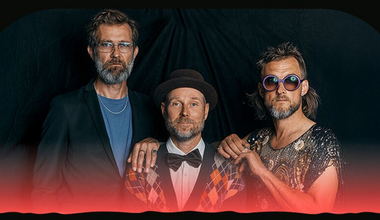 Foto af det tre-mand store band Ægteskab foran en sort baggrund.